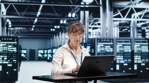 Portrait of young woman using laptop at office