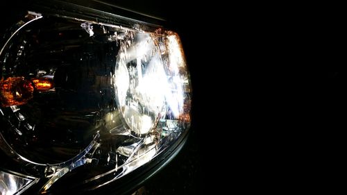Close-up of car headlights against black background