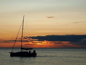 Silhouette boat sailing on sea against sky during sunset