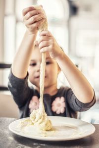 Girl playing with dough in a restaurant 