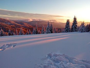 Snow covered landscape against sky