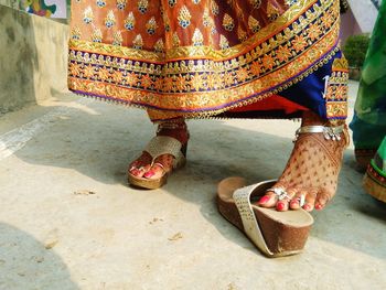 Low section of woman wearing sandal on footpath