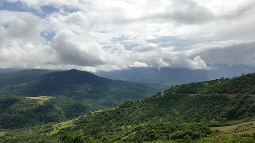 Scenic view of mountains against cloudy sky