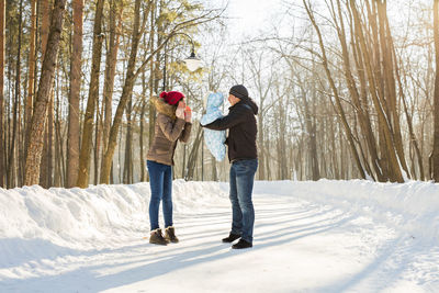 Couple walking on snow covered tree