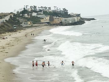 People on beach against clear sky