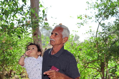 Full length of father with daughter against trees