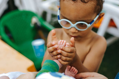 Brother holding sibling leg