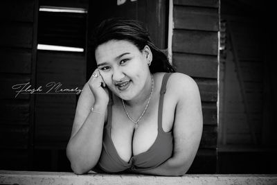 Portrait of a smiling young woman sitting outdoors