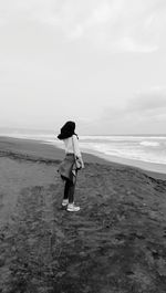 Full length of man standing on beach against sky