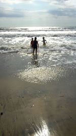 People on beach against sky