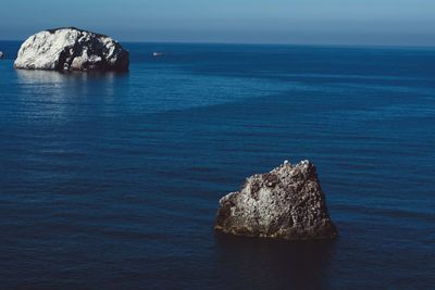 Rock formation in sea against sky