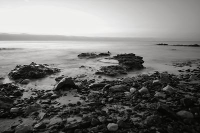 Rocks on beach against sky