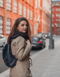 Young woman standing on city street during winter