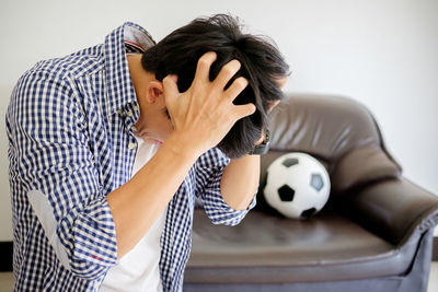 Close-up of angry man tearing his hair out at home