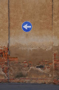 Low angle view of road sign on wall