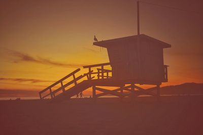 Silhouette of lifeguard hut at sunset