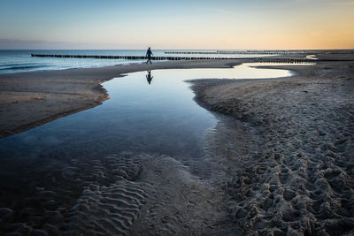 Scenic view of beach against sky during sunset