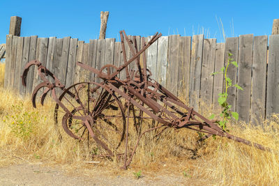 Old wooden fence on field against sky