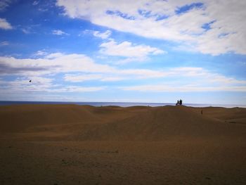 Scenic view of beach against cloudy sky