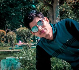 Portrait of young man against plants and trees