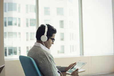 Midsection of man using mobile phone while sitting on table