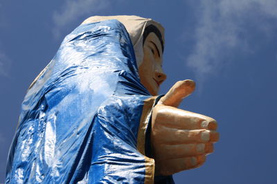 Low angle view of statue against blue sky