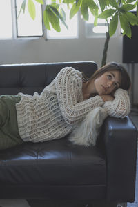 Woman lying on sofa at home