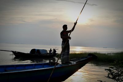 Man in boat on sea against sky