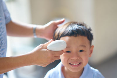 Midsection of woman drying son hair