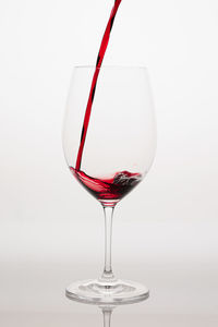 Close-up of wineglass against white background