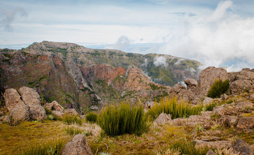 Scenic view of mountains against cloudy sky