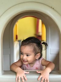 Portrait of cute baby boy looking through window
