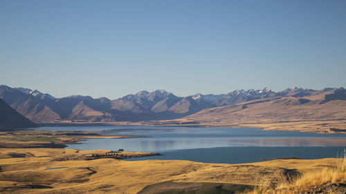 Scenic view of lake and mountains against clear sky