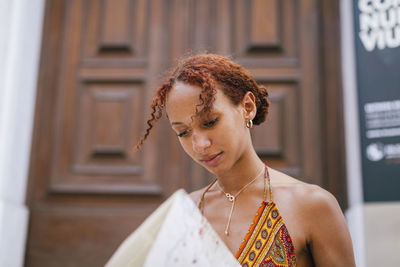 Young woman with curly hair reading map