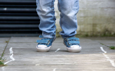 Low section of boy playing on hopscotch