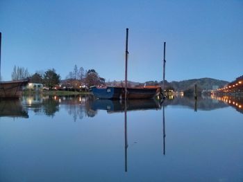 Calm lake against clear blue sky