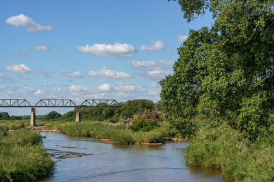 Arch bridge over river against sky