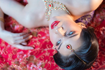 Close-up portrait of young woman lying down