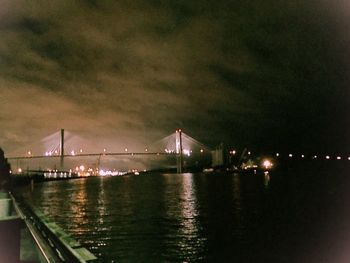 Suspension bridge over river at dusk