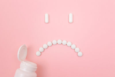 Close-up of pink bottle against colored background
