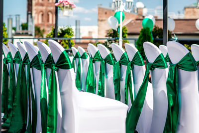 Green tied bow on chairs arranging at wedding