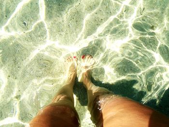 Low section of man relaxing in swimming pool