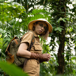 Portrait of woman wearing hat against trees