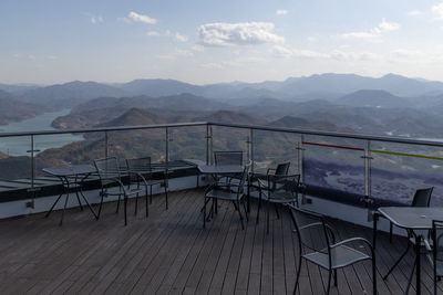 Scenic view of mountains seen through glass window i rooftop against sky