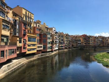 Canal amidst houses in town against clear sky