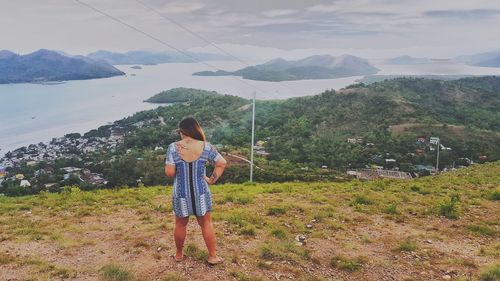 Woman standing on mountain against sky