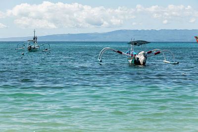 Man swimming in sea against sky