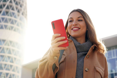 Business young beauty ethnic woman wearing coat using telephone walking outdoors