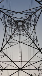 Low angle view of electricity pylon against clear sky