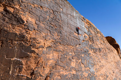 Low angle view of man rock climbing